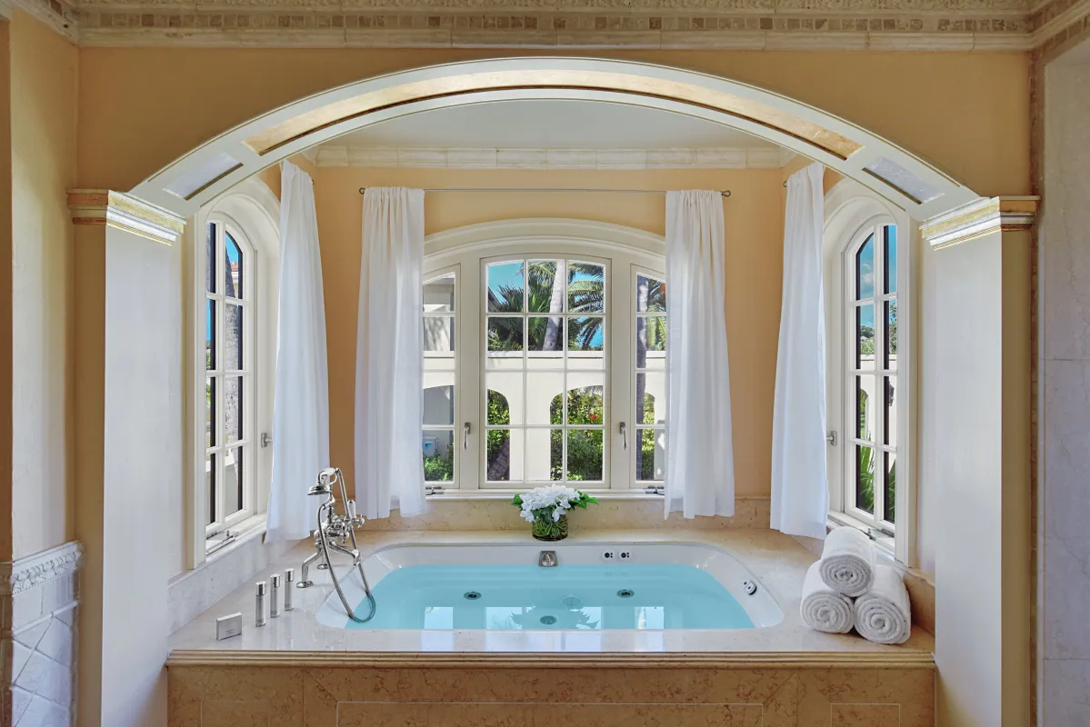 Villa Le Chateau Des Palmiers: Built-in jetted bathtub beneath an arched alcove with windows and garden views