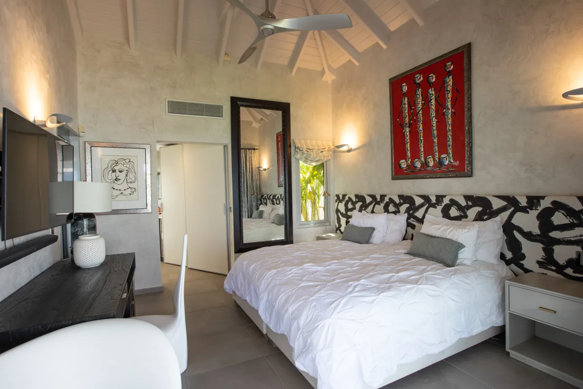 Villa Le Rêve: Bedroom with vaulted ceiling, king bed, patterned headboard, and colorful artwork