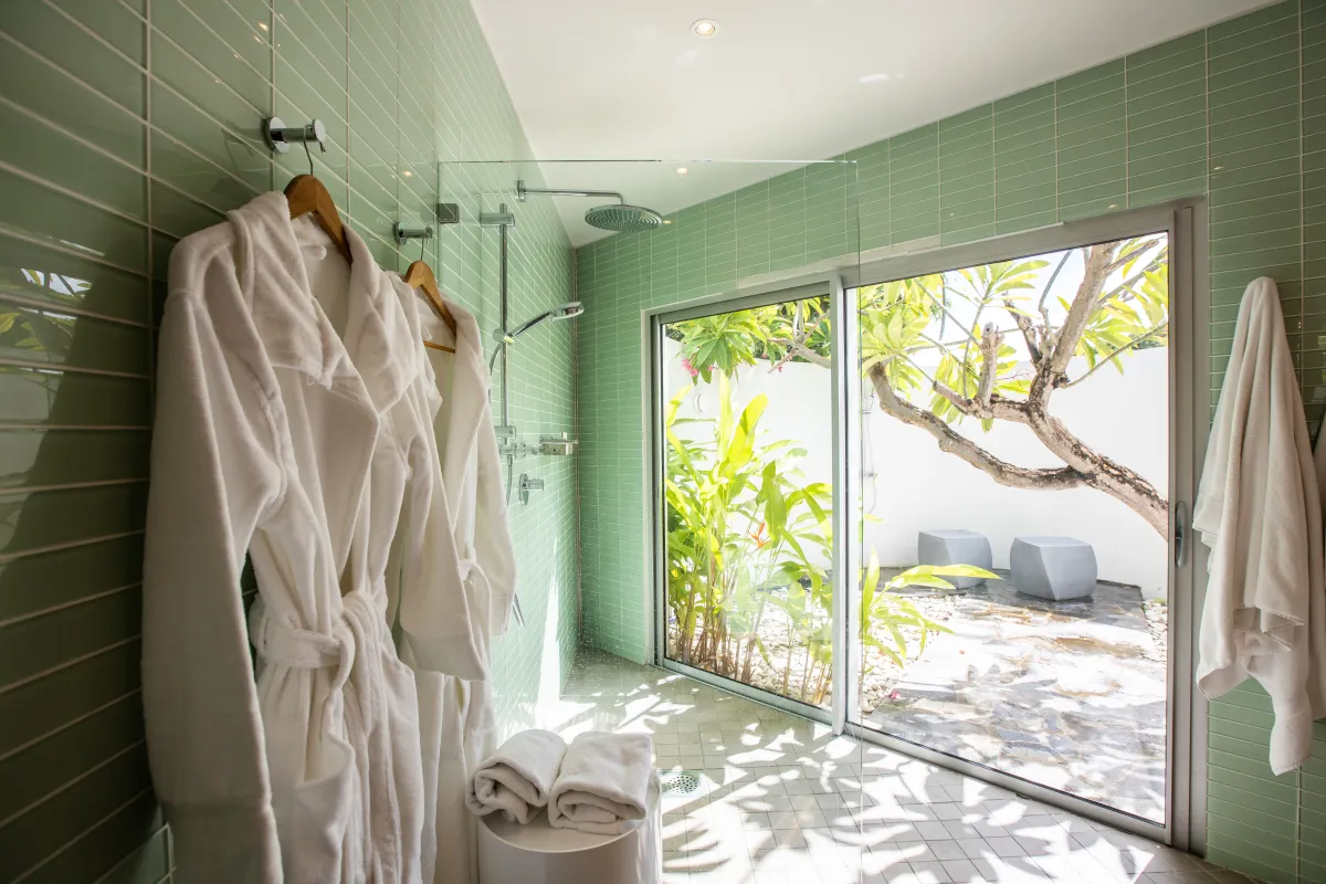 Villa Le Rêve: Modern bathroom with green tiled walls, walk-in shower, and sliding glass doors to a patio