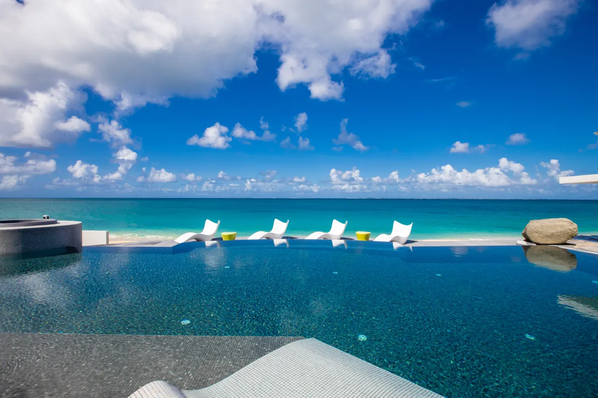 Villa Le Rêve: Infinity pool overlooking the turquoise sea with white sun loungers along the deck