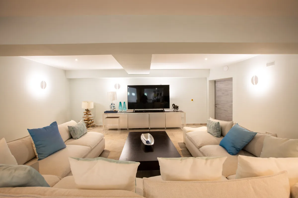 Villa Le Rêve: Living area with plush sofas, a dark wood coffee table, and a flat-screen TV