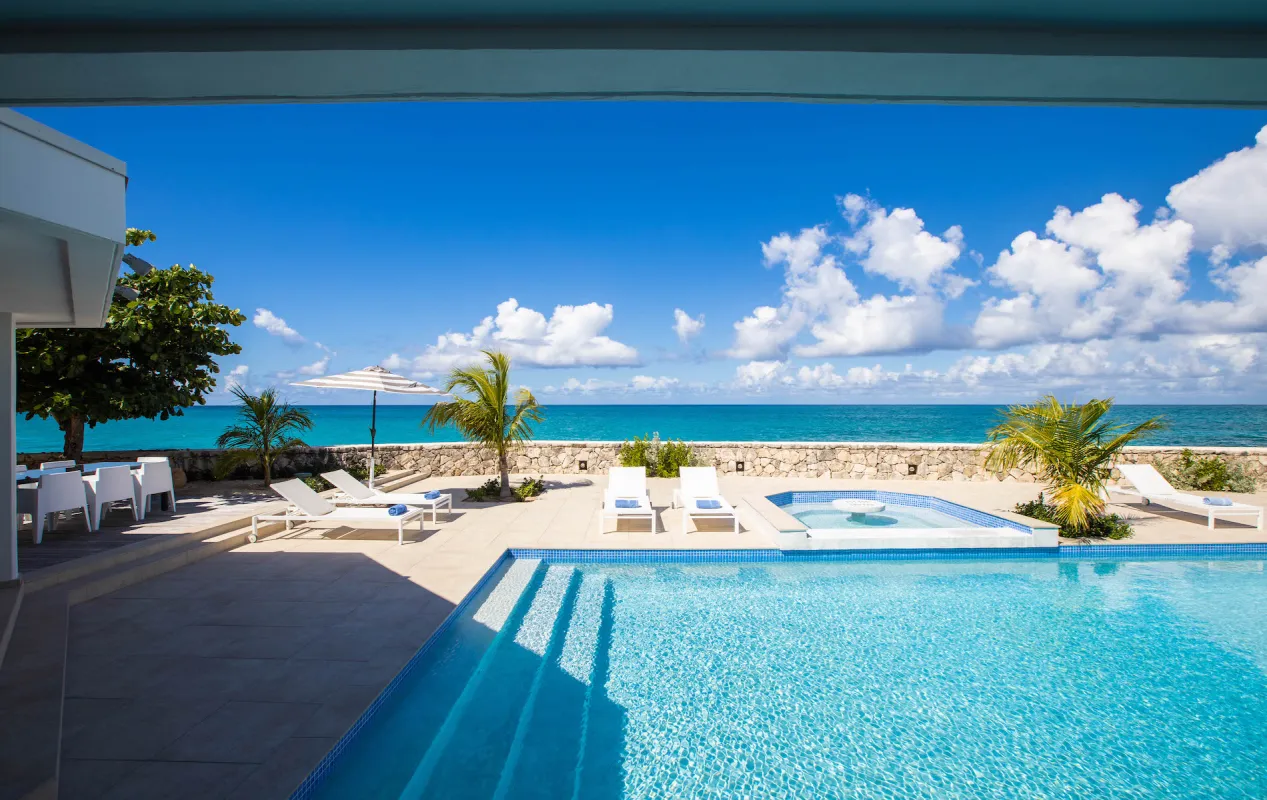Villa L'Ecume des Jours: Swimming pool and sun terrace overlooking the ocean under a partly cloudy sky