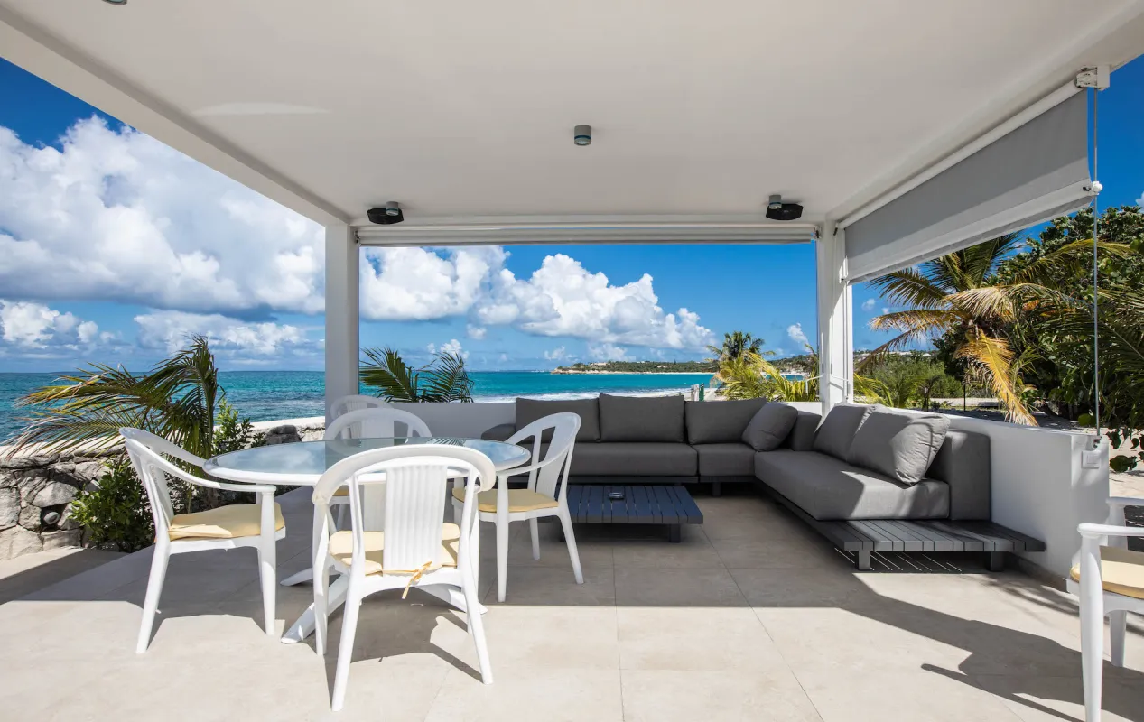 Villa L'Ecume des Jours: Covered patio with dining table, outdoor sectional sofa, and ocean view