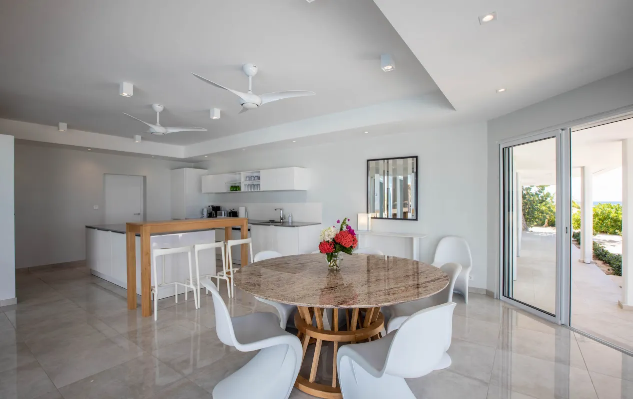Villa L'Ecume des Jours: Open-plan dining area and kitchen with round table and sliding glass doors