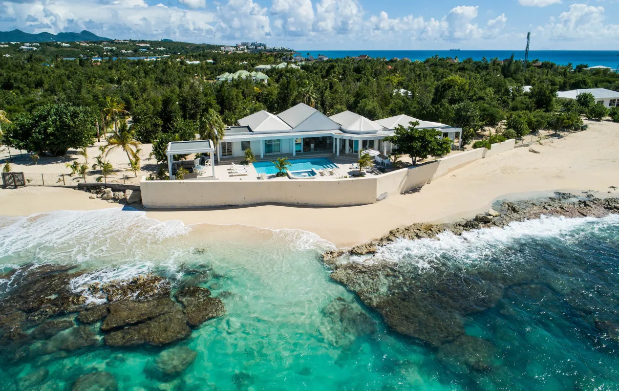 Villa L'Ecume des Jours: Aerial view of a beachfront villa with a swimming pool and turquoise ocean water