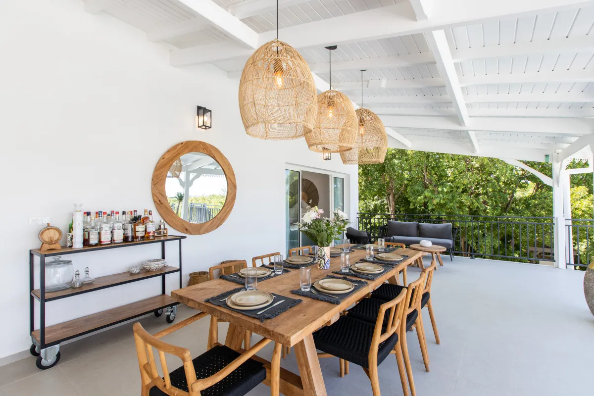 Villa Les Oliviers: Covered terrace dining area with wooden table, woven pendant lights, and bar cart