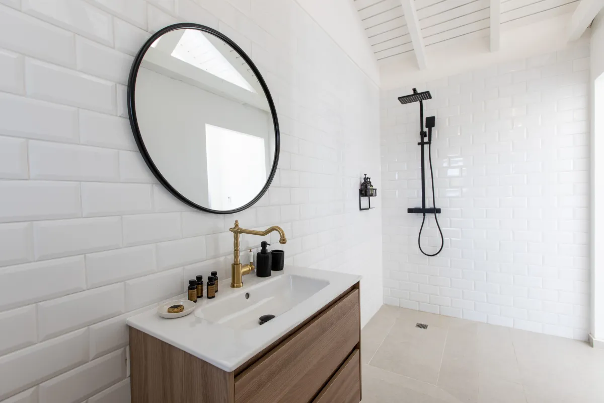 Villa Les Oliviers: Bathroom with white subway tiles, wood vanity, round mirror, and walk-in shower