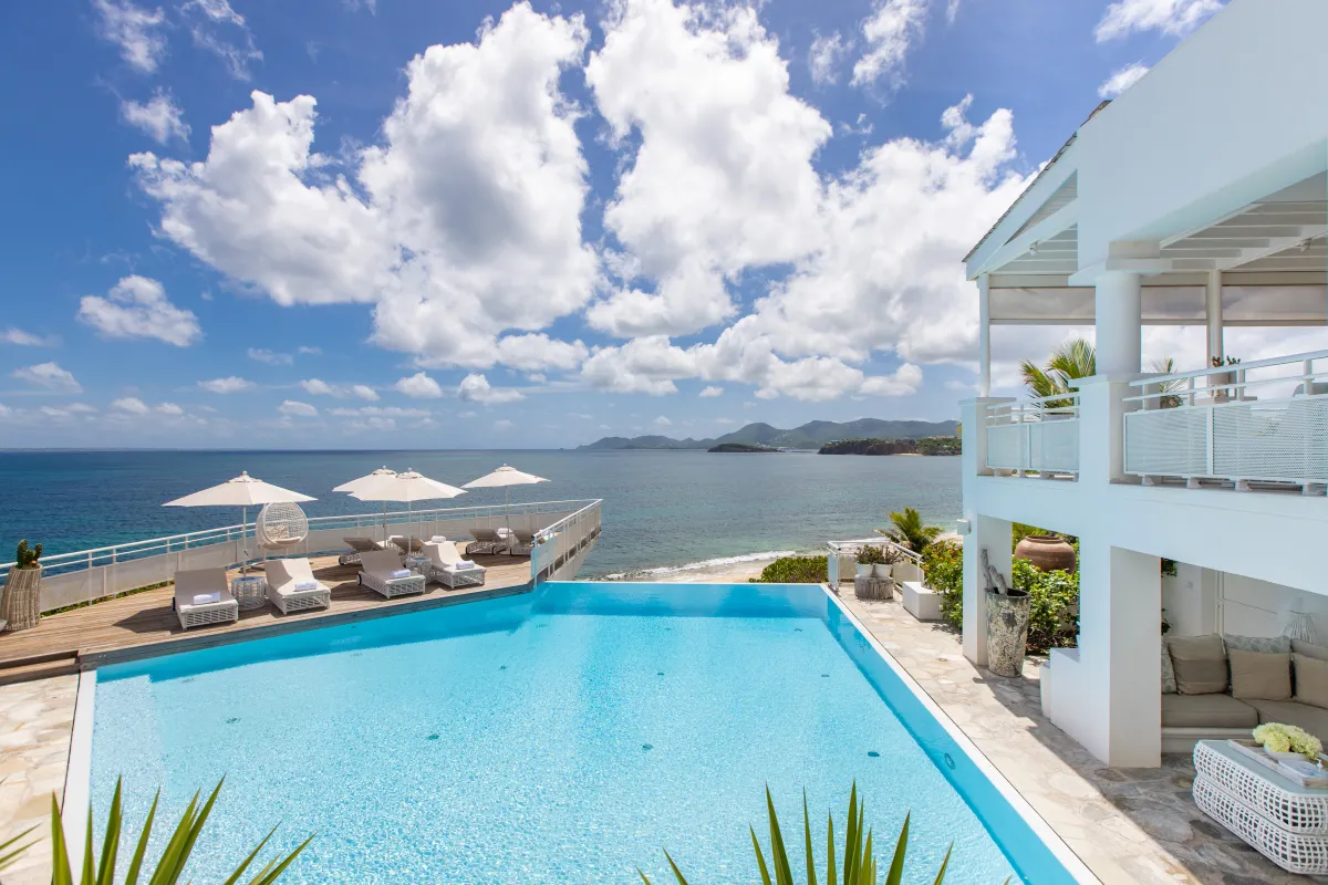 Villa L'Oasis: Infinity swimming pool with sun loungers on a wooden deck overlooking the ocean