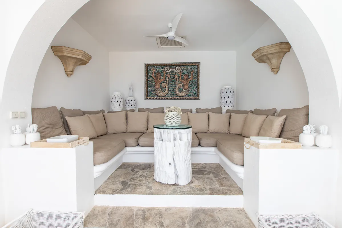 Villa L'Oasis: Covered terrace alcove with built-in wrap-around seating, mosaic wall art, and ceiling fan