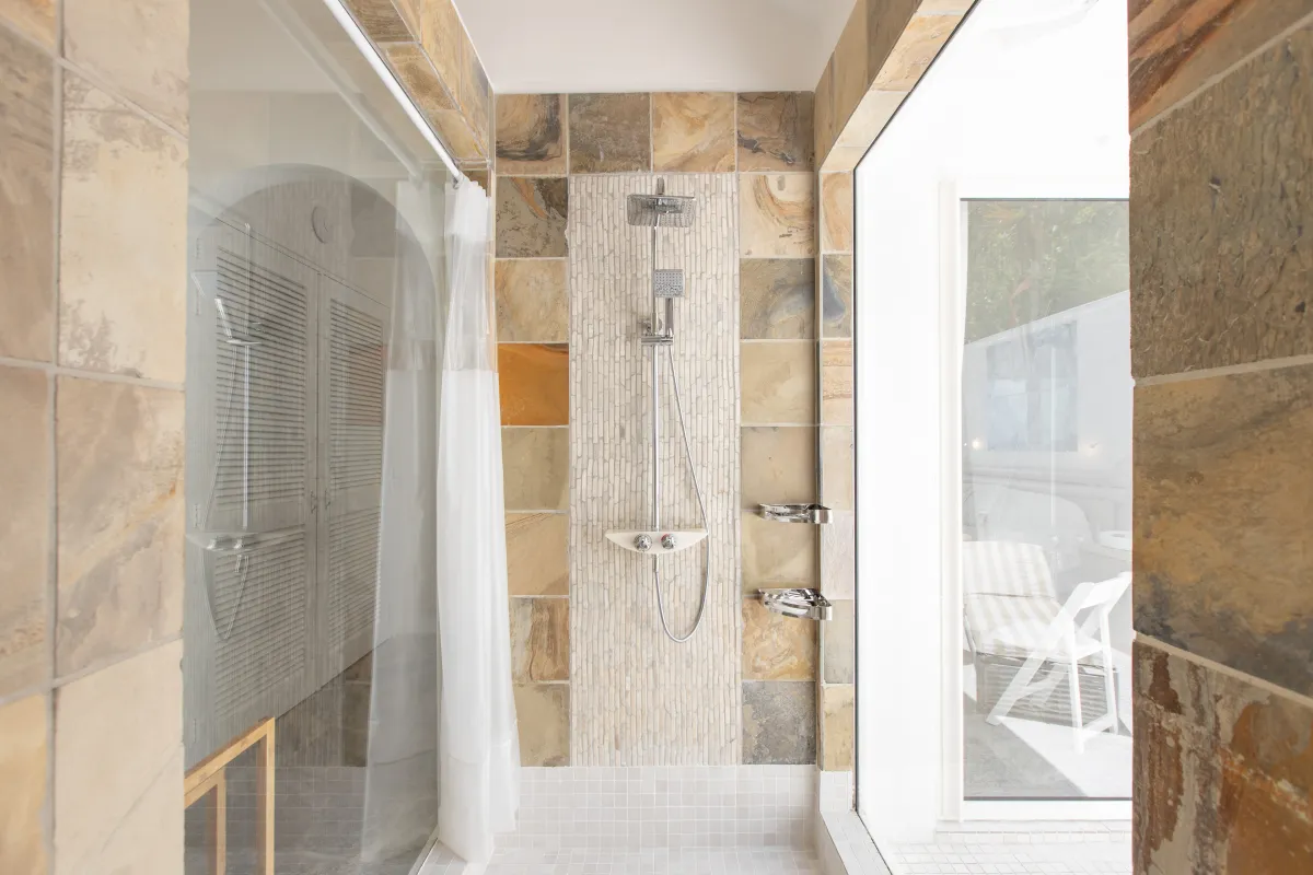 Villa L'Oasis: Walk-in shower with earthy stone tiling and a large window