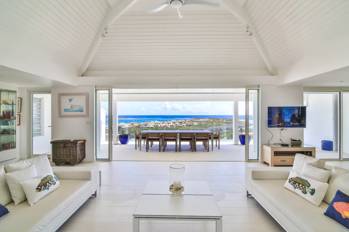 Villa Mango: Bright open living room overlooking an outdoor dining terrace with ocean views