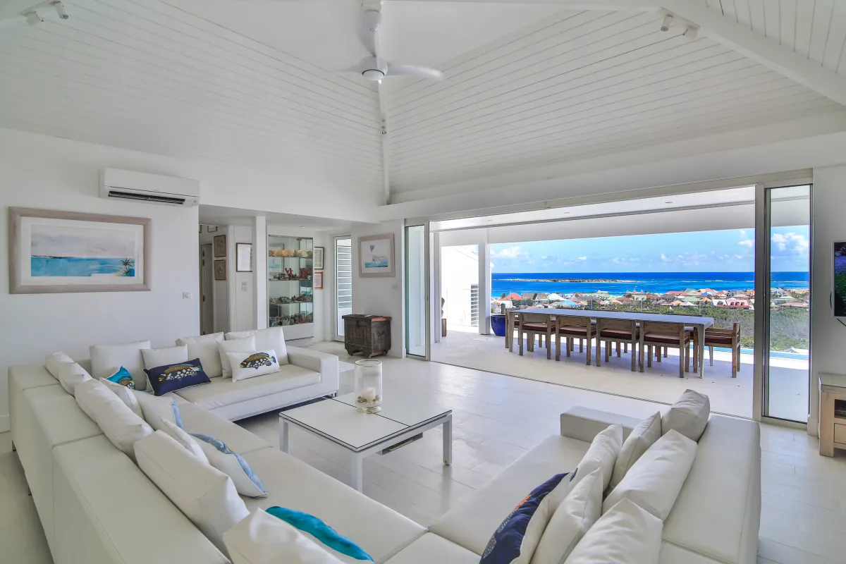 Villa Mango: Spacious white living room opening to a covered terrace with expansive ocean views