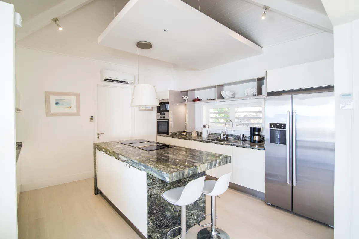 Villa Mango: Modern kitchen with a granite island, bar stools, and stainless steel refrigerator