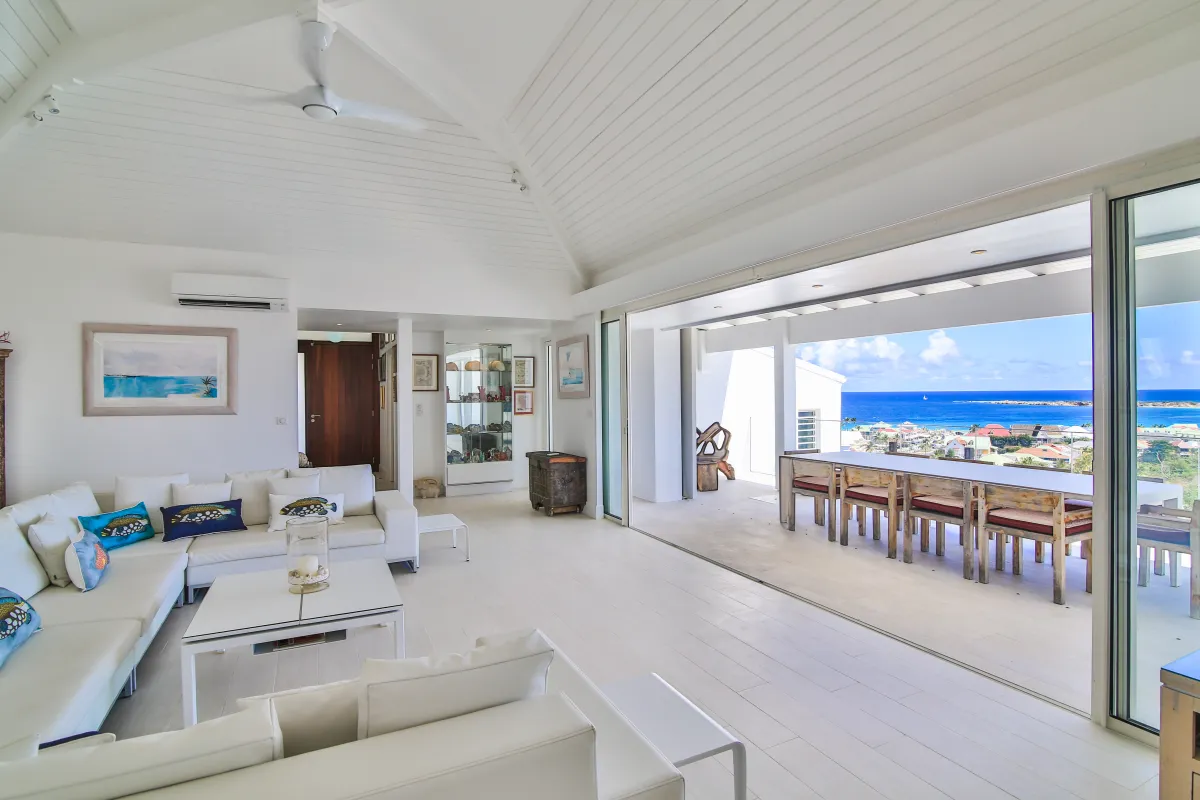 Villa Mango: Bright open living room opening onto a covered terrace with ocean views
