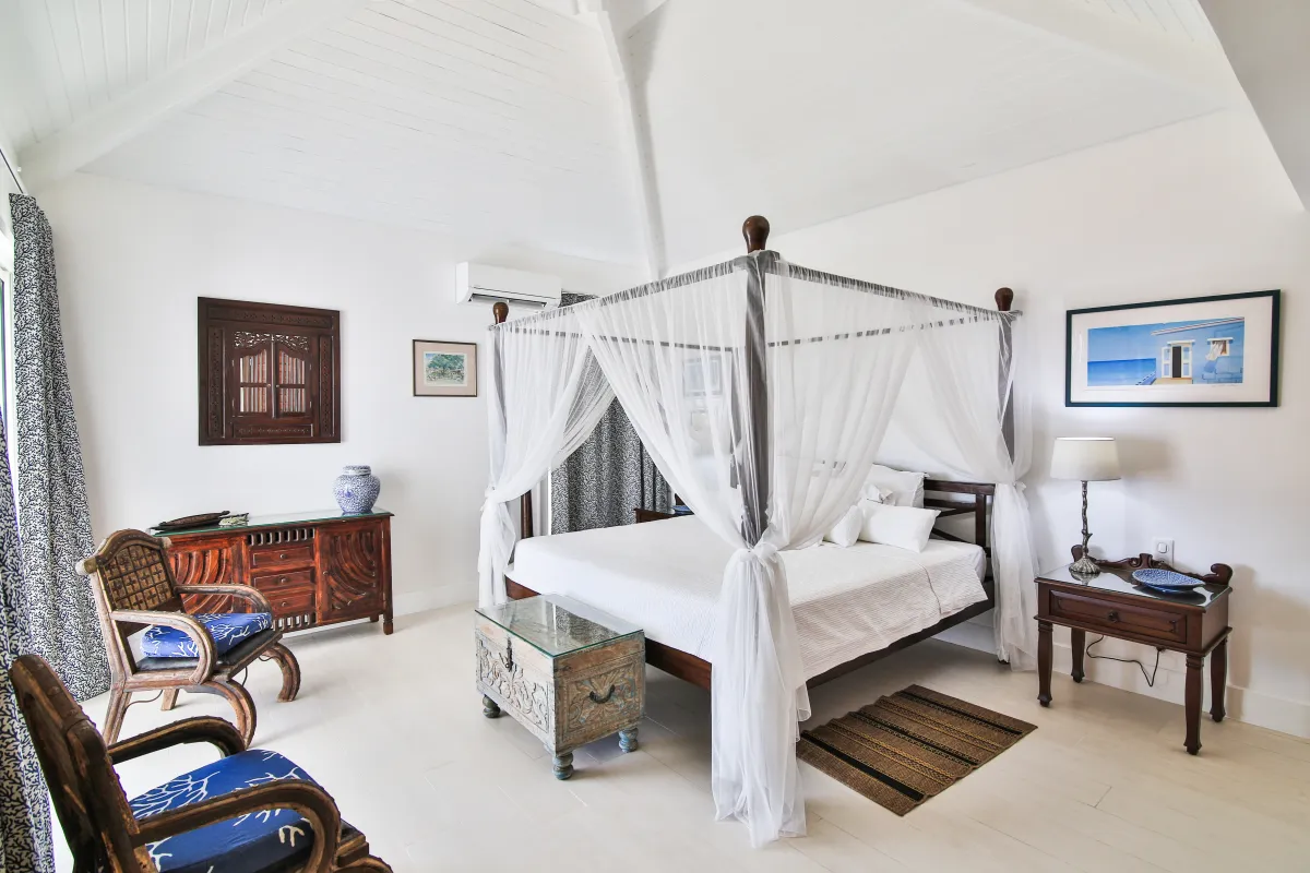 Villa Mango: Bedroom with a four-poster canopy bed, high vaulted ceiling, and wooden furniture
