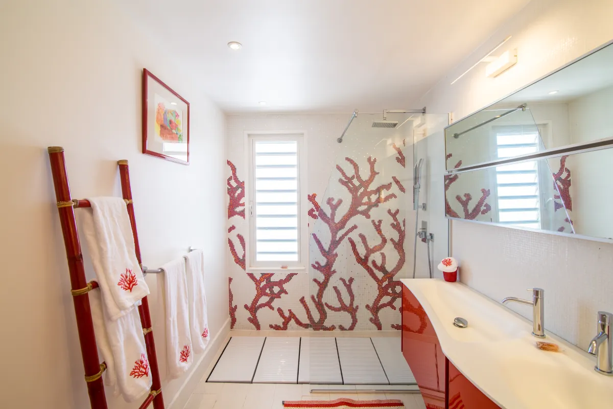 Villa Mango: Modern bathroom with a coral motif tiled walk-in shower and red vanity