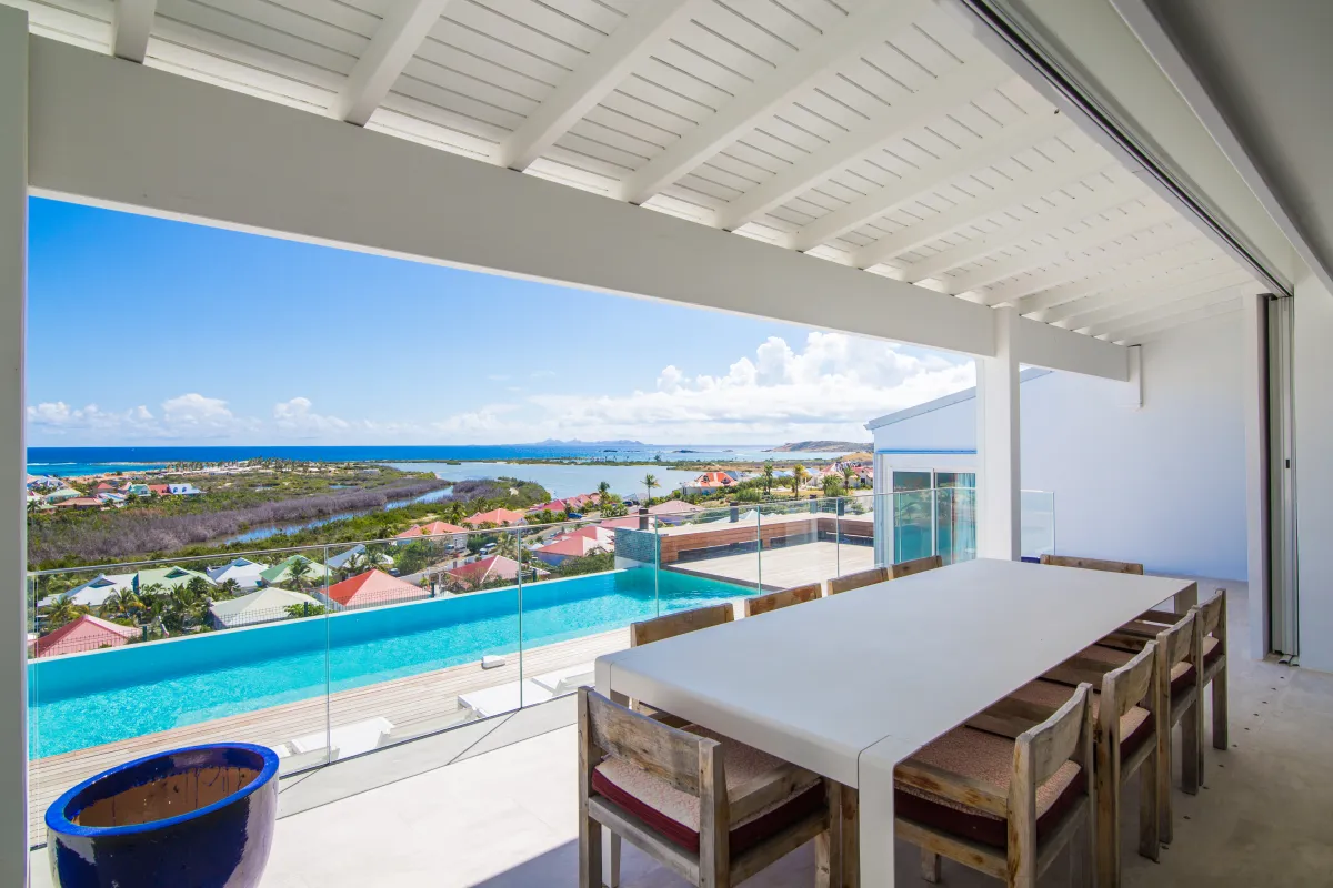 Villa Mango: Outdoor dining table on a covered terrace overlooking an infinity pool and ocean