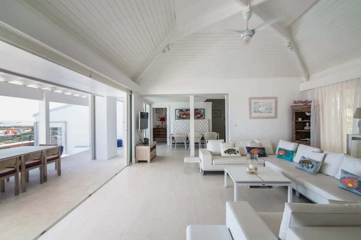 Villa Mango: Open-concept living room with white sectional sofas and doors opening to a terrace