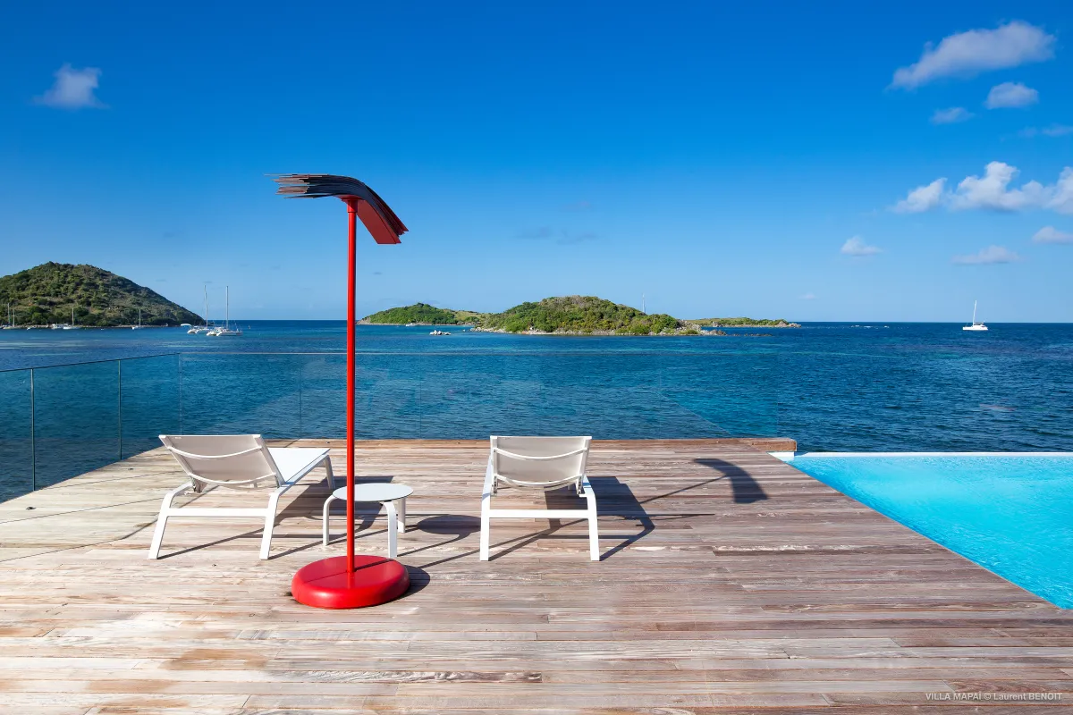 Villa Mapai: Sun loungers on a wooden deck overlooking the ocean with islands in the distance
