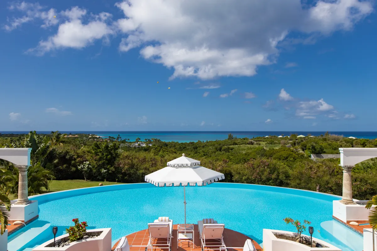 Villa Mariposa: Large curved swimming pool and sun loungers overlooking tropical greenery and the ocean