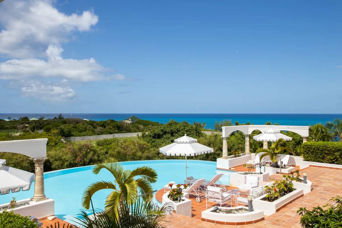 Villa Mariposa: Terrace and curved swimming pool overlooking lush greenery and the turquoise sea