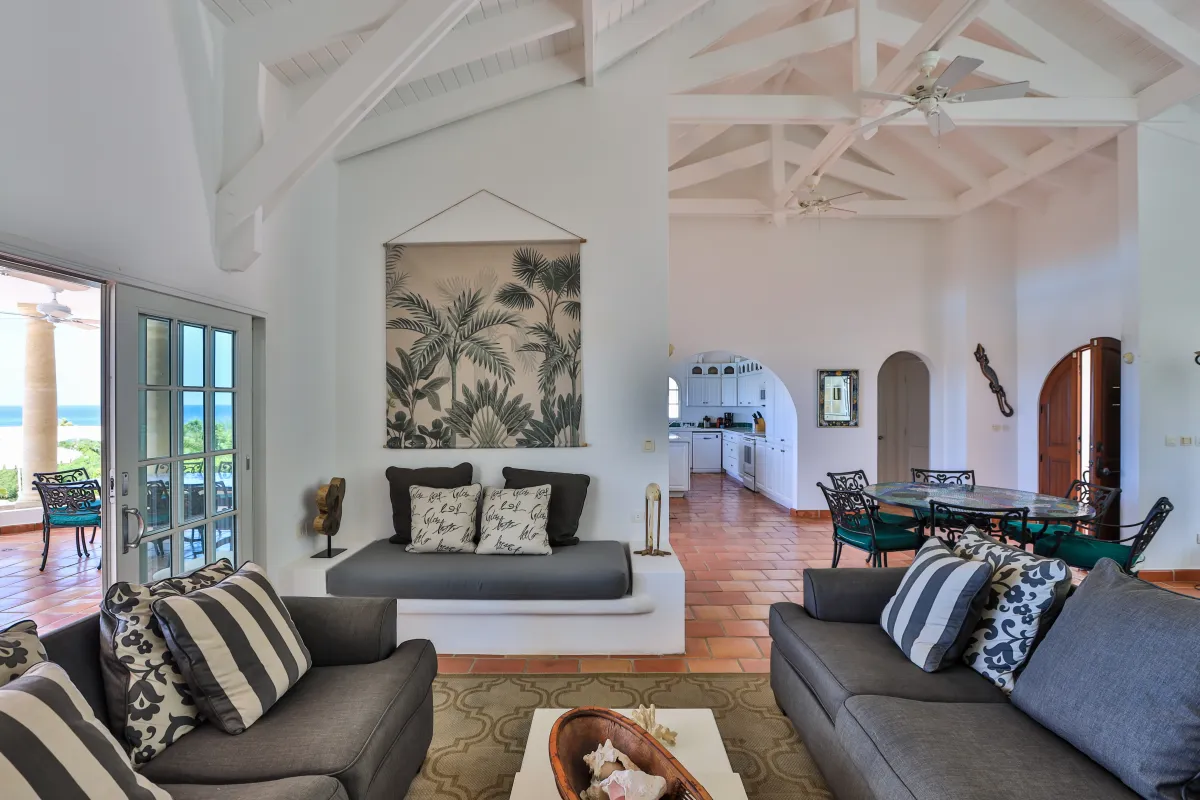 Villa Mariposa: Spacious living room with vaulted ceilings, gray sofas, tiled floor, and adjoining dining area