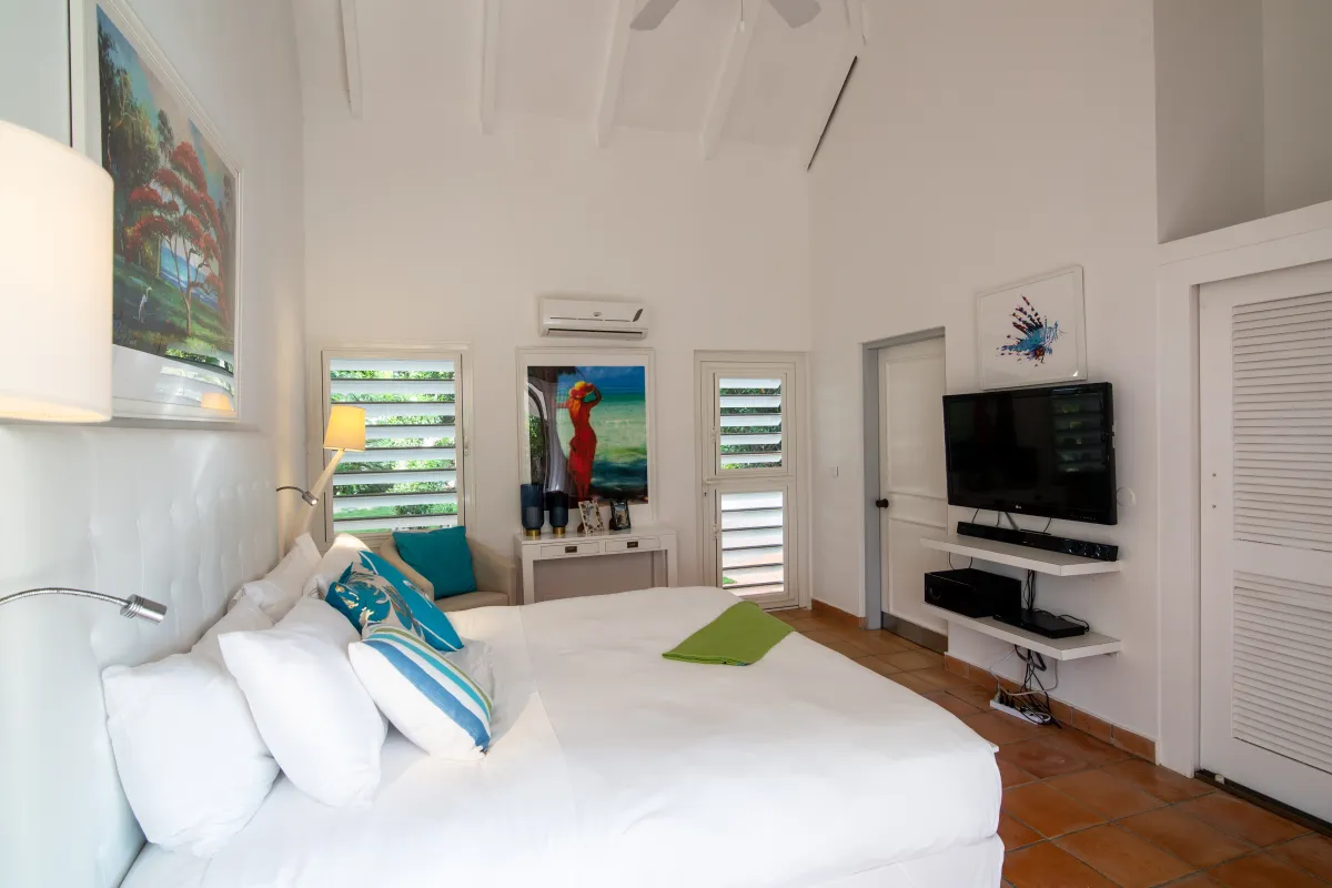 Villa Mes Amis: Bedroom with white bedding, high vaulted ceiling, and wall-mounted television