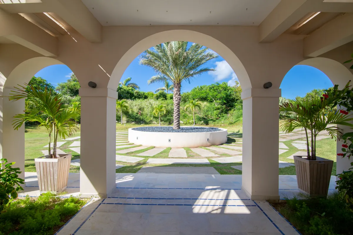Villa Mes Amis: Arched entryway framing a landscaped courtyard with a central palm tree planter