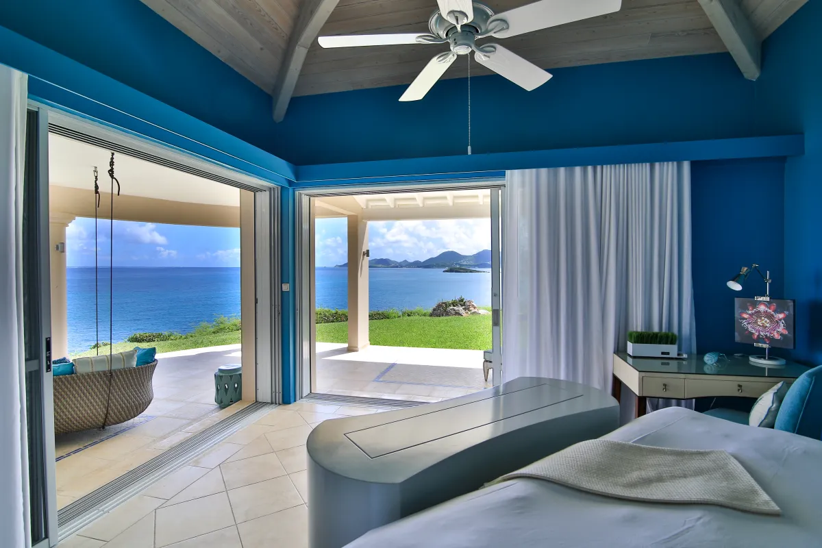 Villa Mes Amis: Bedroom with blue walls and sliding glass doors opening to a terrace and ocean view