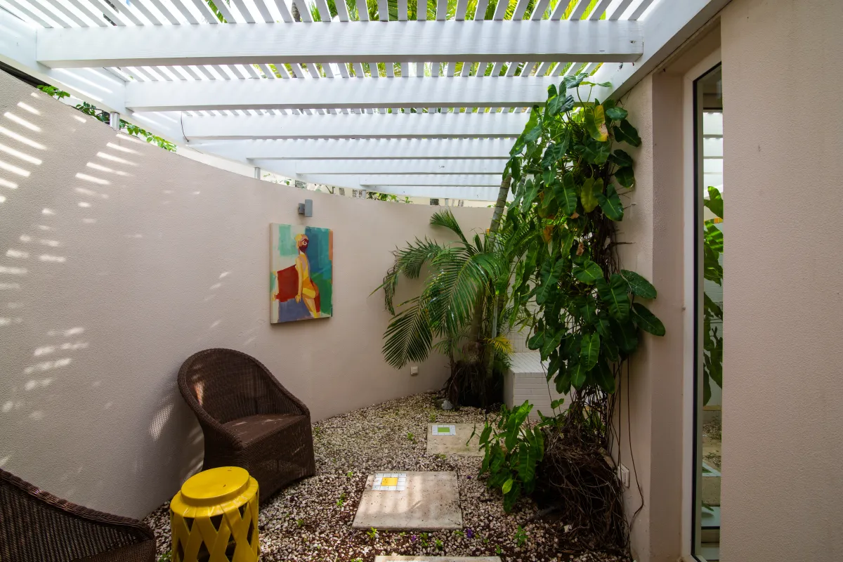 Villa Mes Amis: Enclosed patio with wicker chairs under a white pergola roof