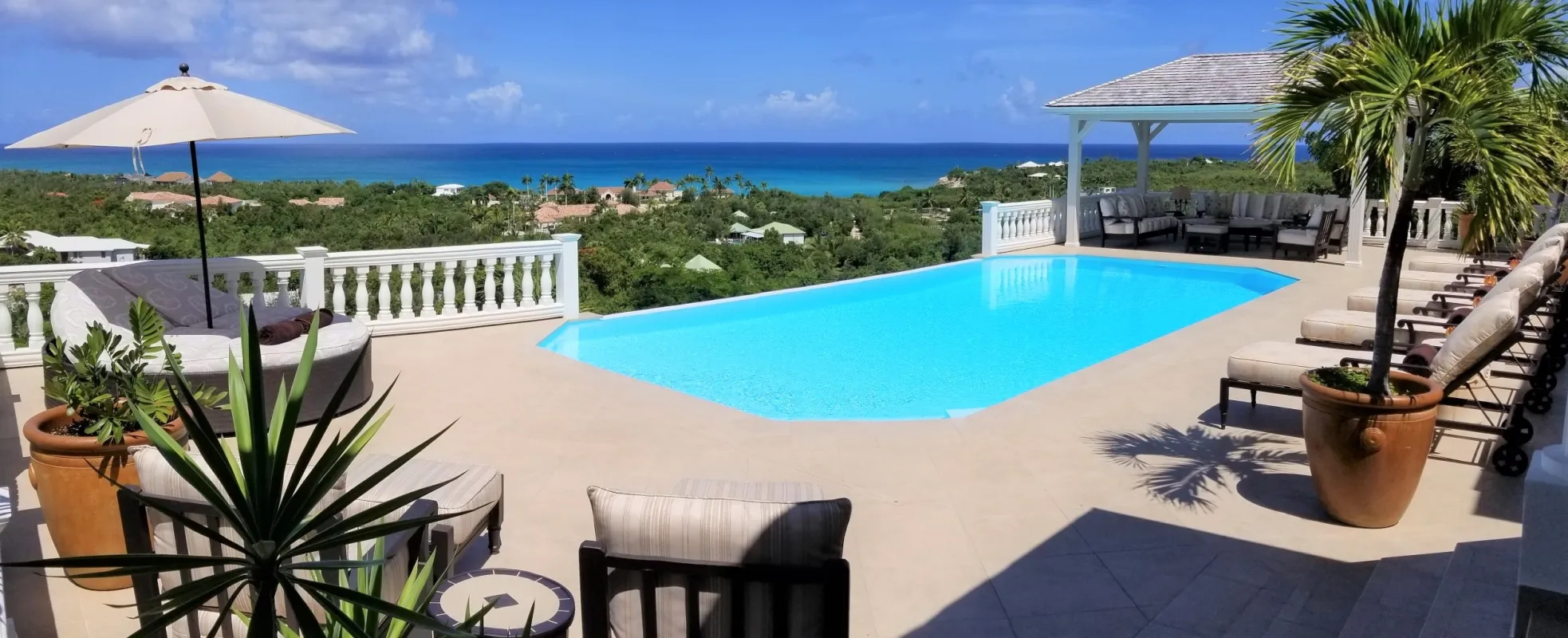 Villa Mille Fleurs: Swimming pool and sun terrace with loungers overlooking coastal greenery and the ocean