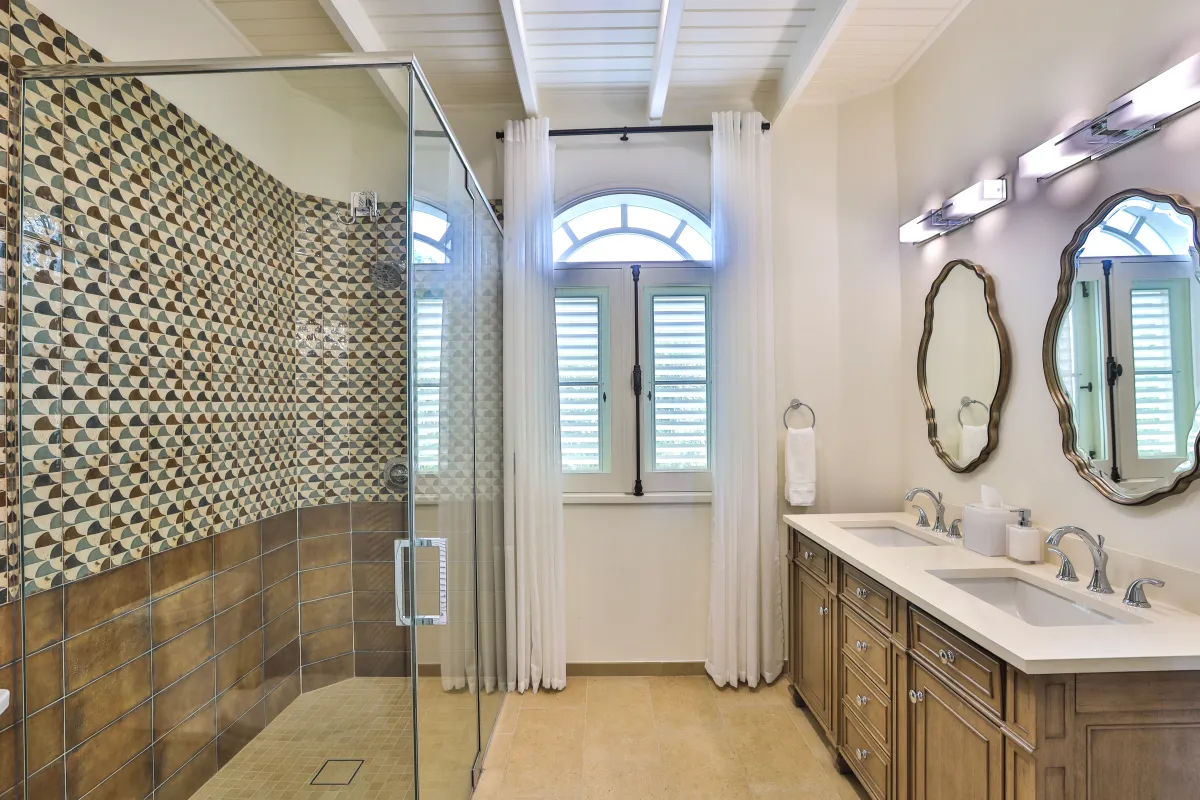 Villa Mille Fleurs: Spacious bathroom with glass walk-in shower, double sink vanity, and arched window