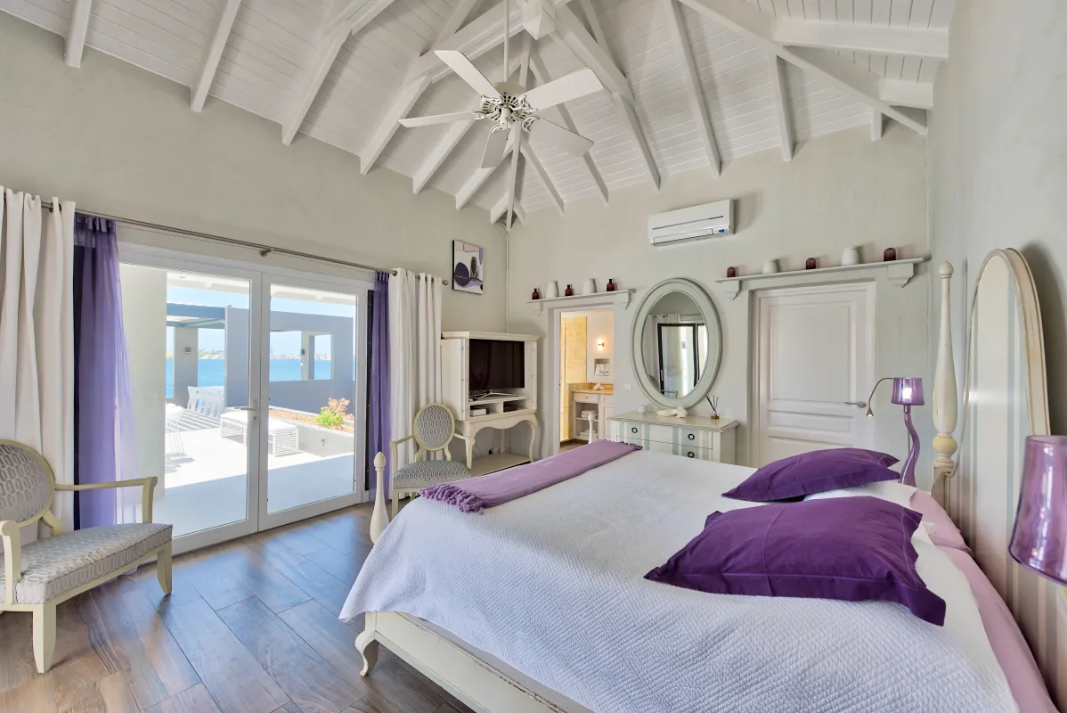 Villa Mirabelle: Bedroom with vaulted ceiling purple accents and sliding doors leading to a terrace