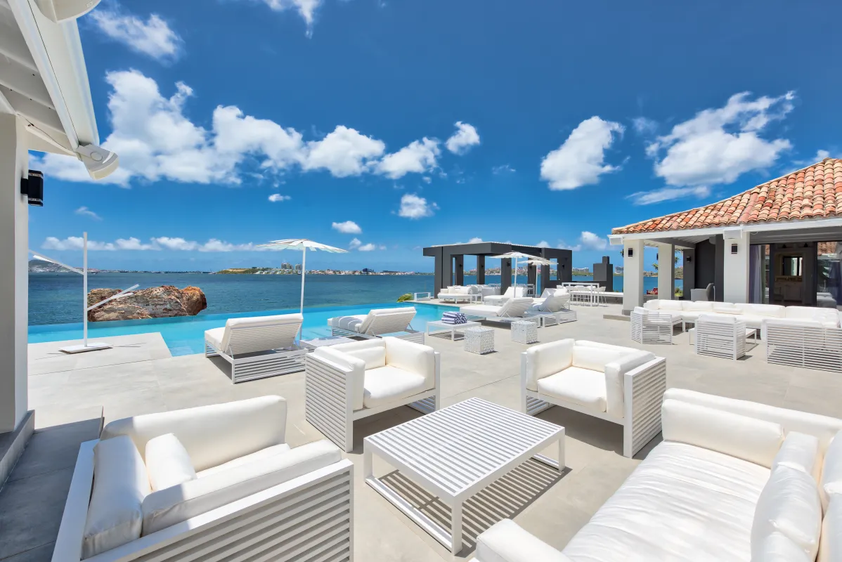Villa Mirabelle: Sun terrace with white lounge furniture overlooking an infinity pool and the sea
