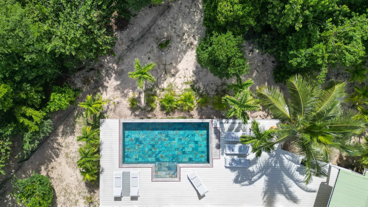 Villa Monchal: Aerial view of a turquoise swimming pool and wooden deck surrounded by tropical trees
