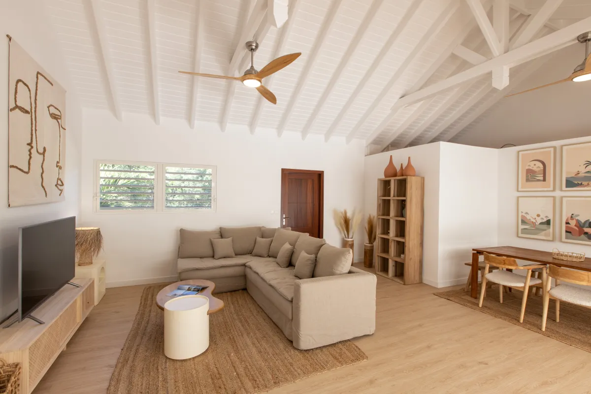 Villa Monchal: Open living room with vaulted ceiling, sectional sofa, television, and dining area