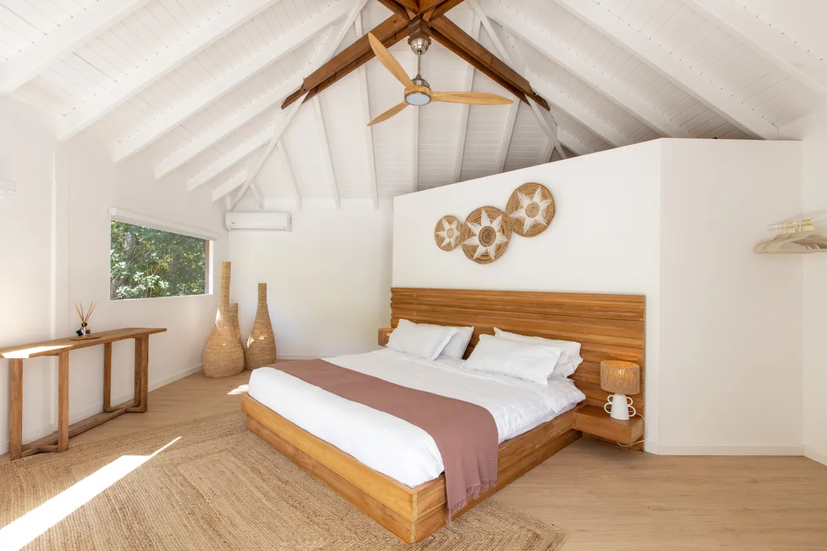 Villa Monchal: Bedroom with wood platform bed, vaulted beamed ceiling, and natural wood accents