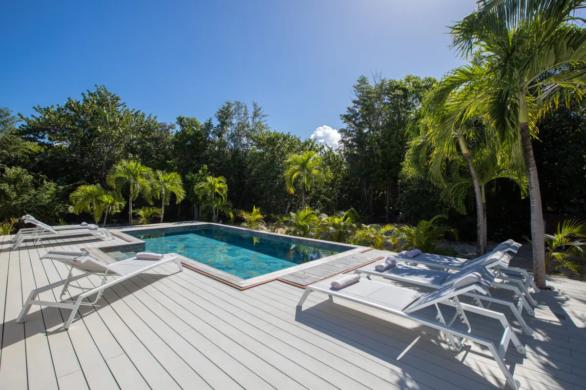 Villa Monchal: Swimming pool with sun loungers on a wooden deck surrounded by tropical palm trees