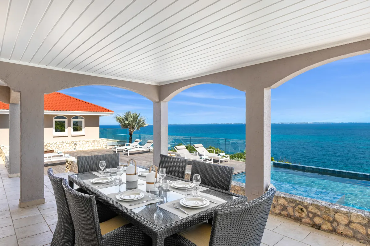 Villa Mongoose Run: Covered terrace with outdoor dining table overlooking the swimming pool and ocean