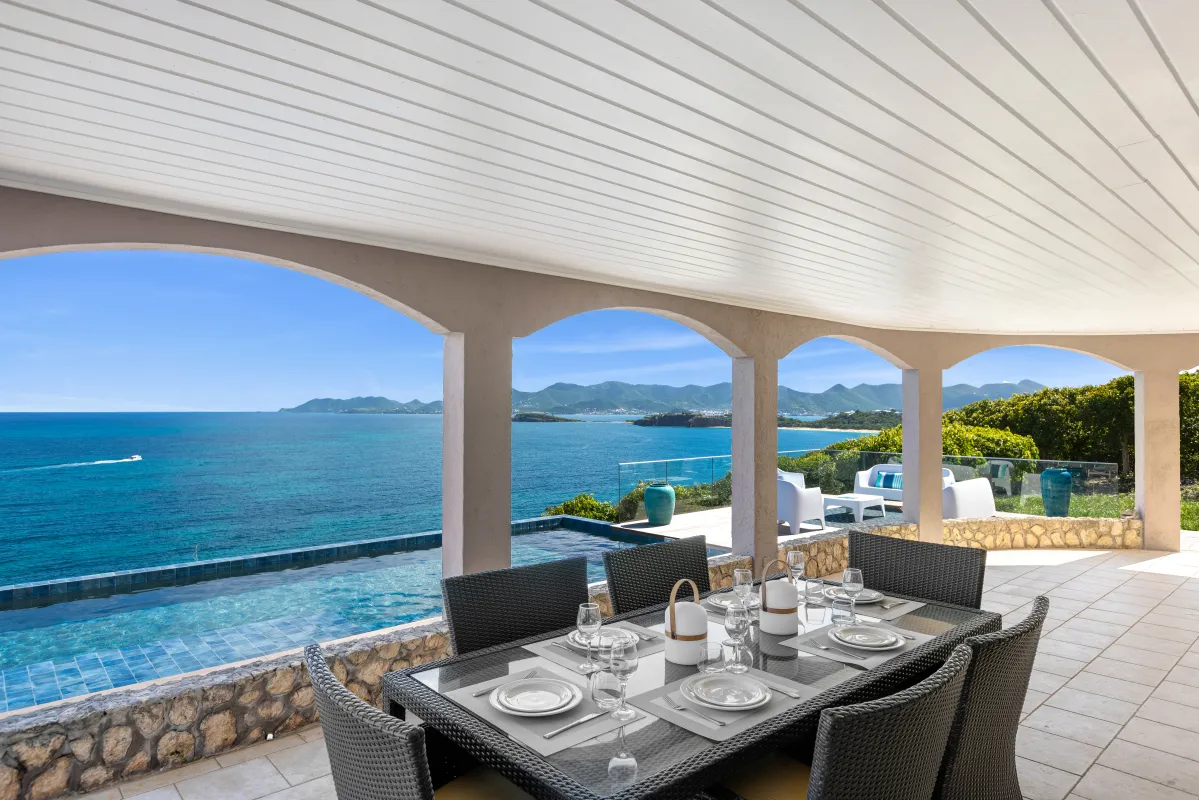 Villa Mongoose Run: Covered terrace with an outdoor dining table overlooking the infinity pool and ocean