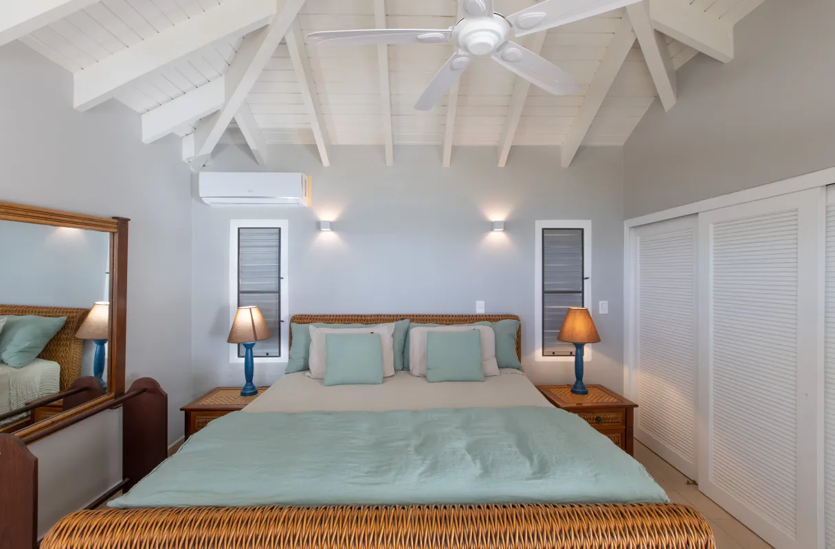 Villa Mongoose Run: Bedroom with woven wicker bed, white vaulted ceiling, and matching nightstands with lamps