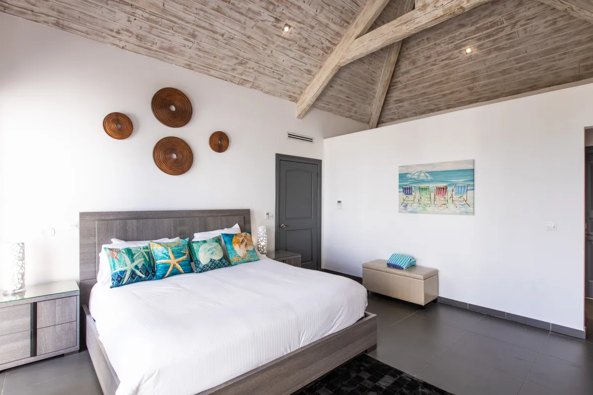 Villa Monte Verde: Bedroom with a king bed under a vaulted wooden ceiling with coastal accents