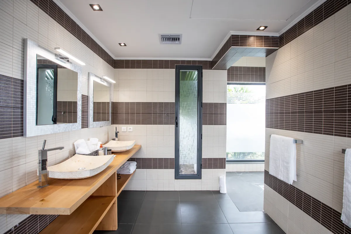 Villa Monte Verde: Bathroom with double vessel sinks on a wooden vanity and striped tile walls
