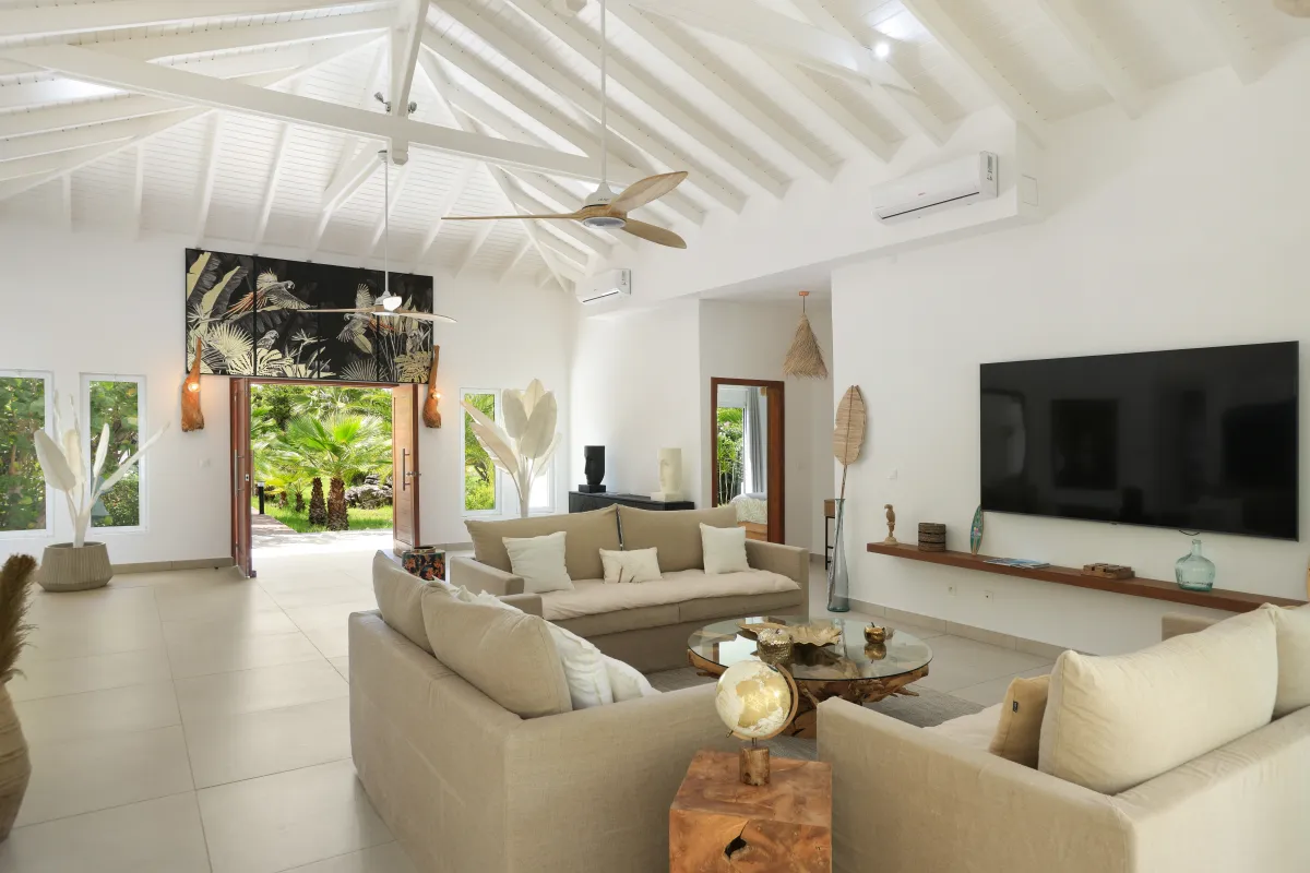 Villa Nirvana: Spacious living room with vaulted exposed beam ceiling and open doorway to garden