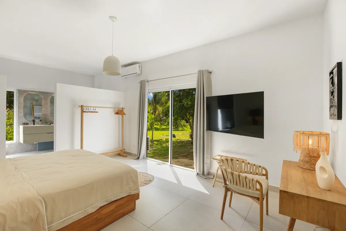 Villa Nirvana: Bedroom with bed facing sliding glass doors opening to a garden