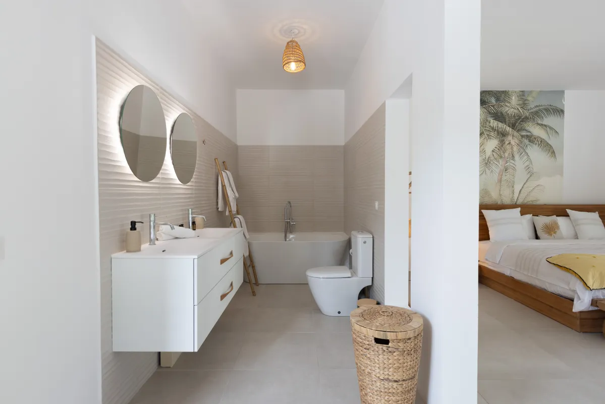 Villa Nirvana: Ensuite bathroom with double vanity, soaking tub, and view into an adjacent bedroom