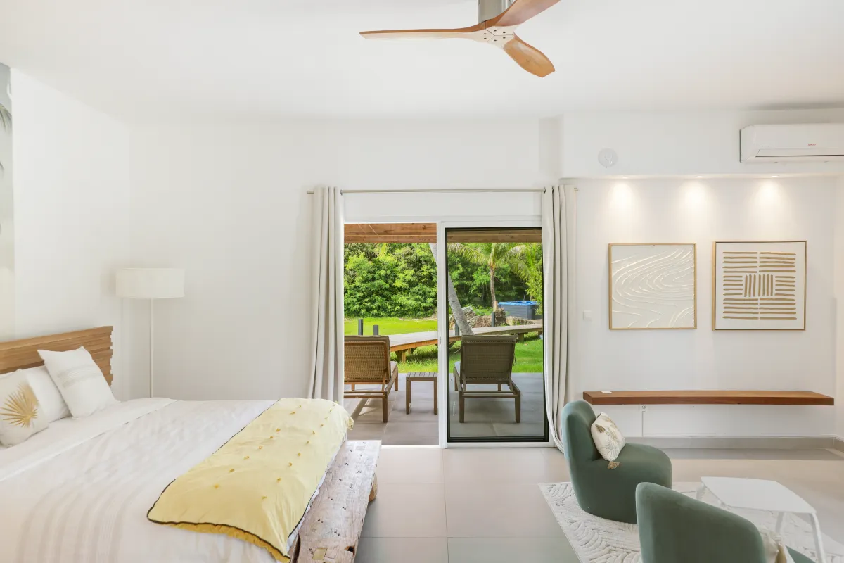 Villa Nirvana: Bright bedroom with a king bed and glass doors opening to a garden patio
