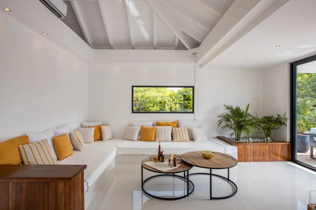 Villa Nuit D'Etoiles: Bright living room with built-in corner sofa, vaulted ceiling, and round coffee tables
