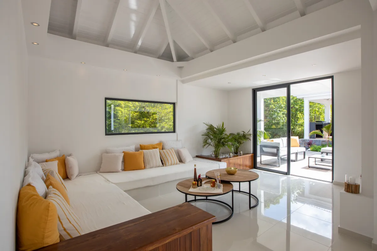 Villa Nuit D'Etoiles: Bright living area with built-in seating, vaulted ceiling, and sliding doors to the terrace