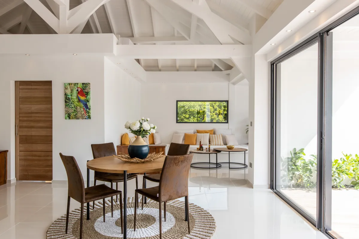 Villa Nuit D'Etoiles: Open-concept dining area with round wooden table and chairs under a high vaulted ceiling